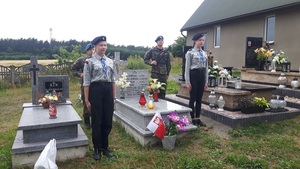 Warta honorowa i zapalenie biało-czerwonych zniczy na cmentarzu parafialnym w Dąbrowie.