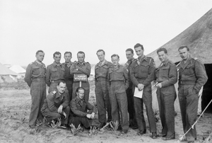 Polscy oficerowie ubrani w battledress-y stoją przed namiotem wojskowym. Oficer piąty od prawej ma na ramieniu naszywkę 7 Zapasowej DP, używanej od końca 1942 r. Zdjęcie wykonane prawdopodobnie w Iraku, być może w marcu 1943 r. koło Bagdadu, podczas kursu „Poznaj swego wroga”.