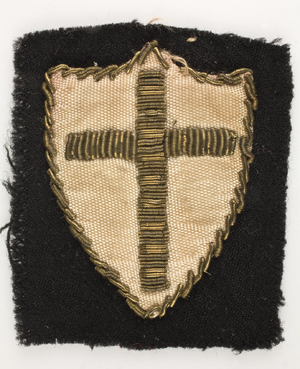 Noszona przez por. Władysława Jaksana odznaka honorowa 2 Korpusu Polskiego, tzw. „tarcza krzyżowców” – odznaka rozpoznawcza 8 Armii Brytyjskiej noszona przez żołnierzy 2 Korpusu Polskiego po bitwie o Monte Cassino.