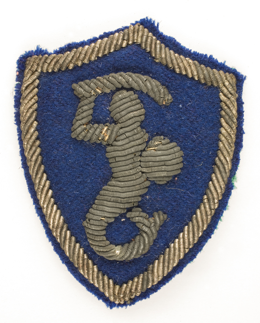 Noszona przez por. Władysława Jaksana odznaka rozpoznawcza 2 Korpusu Polskiego – syrenka – noszona na lewym rękawie munduru żołnierzy Bazy 2 Korpusu Polskiego. Syrenka wyhaftowana srebrną nicią na granatowym tle.