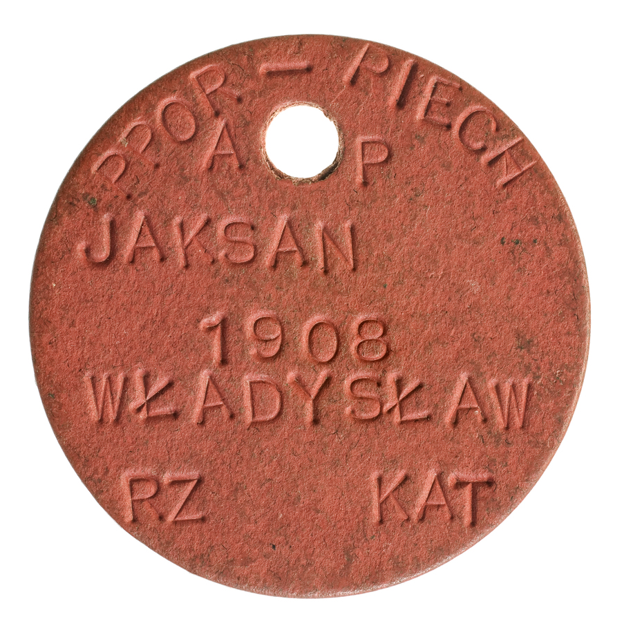 Nieśmiertelnik (część czerwona) ppor. piechoty Władysława Jaksana. W górnej części napis AP – Armia Polska, data urodzenia: 1908, wyznanie rzymsko-katolickie.