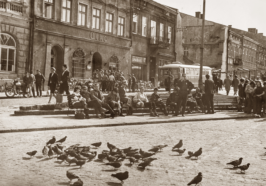 Zdjęcie 028. Rynek w Rzeszowie. Widok na siedzibę PTTK w Rzeszowie. Na zdjęciu widoczny jest autobus marki SAN H100 należący do rzeszowskiego oddziału PTTK w Rzeszowie. Na ławeczce siedzi Anna Leszczyńska – szósta od lewej, w jasnej kurtce. Ok. 1968 r.