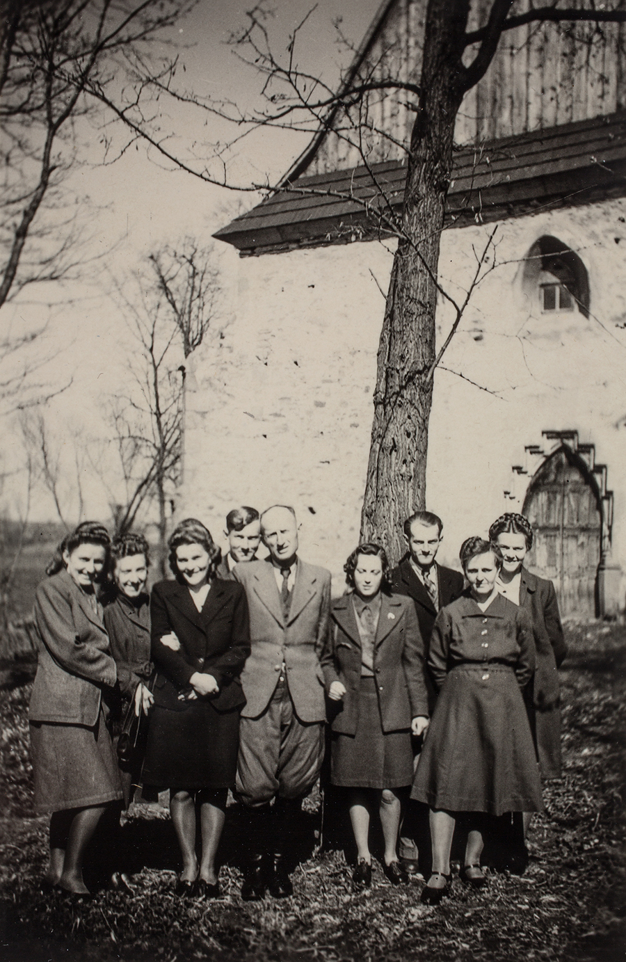 Zdjęcie 012. Józef Laska (piąty od lewej) w towarzystwie nierozpoznanych mężczyzn i kobiet. Na drugim planie XV-wieczny kościół pw. św. Zofii w Bobowej.