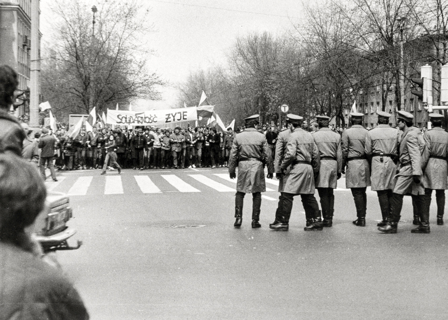 Zdjęcie 016. Sympatycy i działacze NSZZ „Solidarność” stoją na czele pochodu na skrzyżowaniu ul. Stołecznej z ul. Krasińskiego w Warszawie, zablokowani przez milicjantów ustawionych w charakterystycznym kordonie, 1 maja 1985 r.