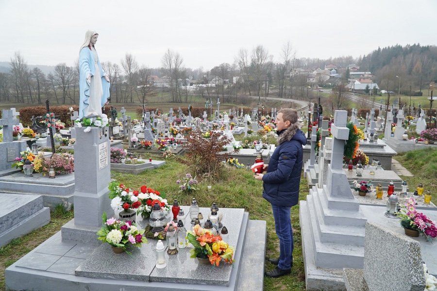 Dr Marcin Bukała pali znicze na grobie kpr. Jana Staszczaka – żołnierza Placówki AK Hyżne. Fot. IPN Rzeszów
