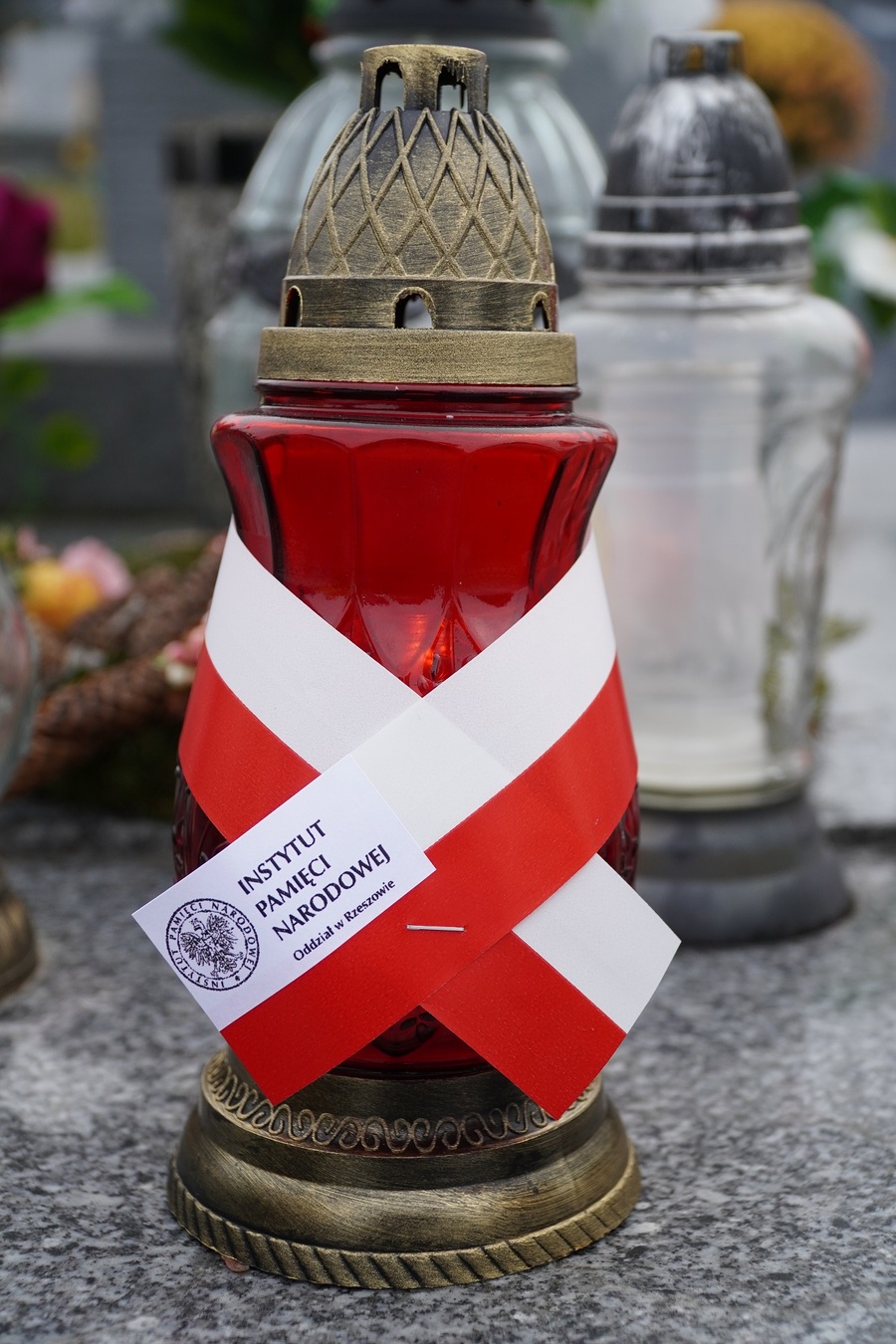 Dr Marcin Bukała pali znicze na grobie kpr. Jana Staszczaka – żołnierza Placówki AK Hyżne. Fot. IPN Rzeszów