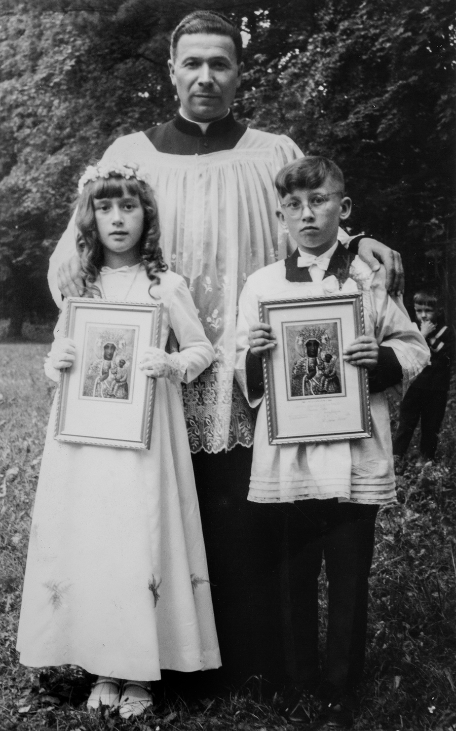 Rodzeństwo Małgorzata i Jan Niemcowie z ks. Czesławem Wojnarem w dniu przyjęcia Pierwszej Komunii Świętej w kościele w Dobrzechowie 4 czerwca 1967 r.